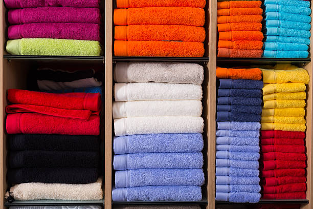 Many colored cotton towels on shelfs