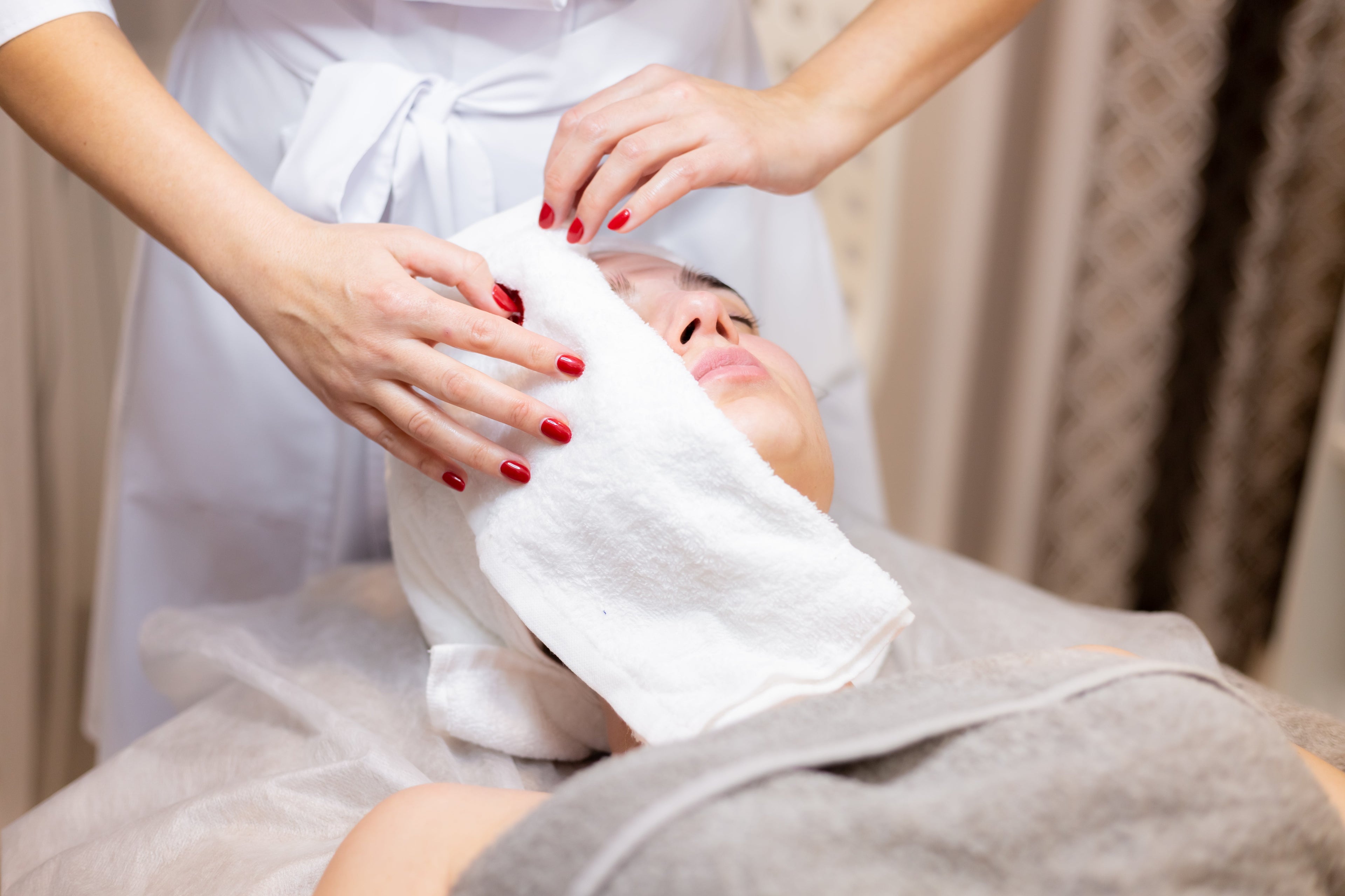 Girl receiving hot towel facial treatment